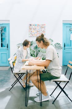 Two individuals working in a sunny, modern indoor coworking environment.